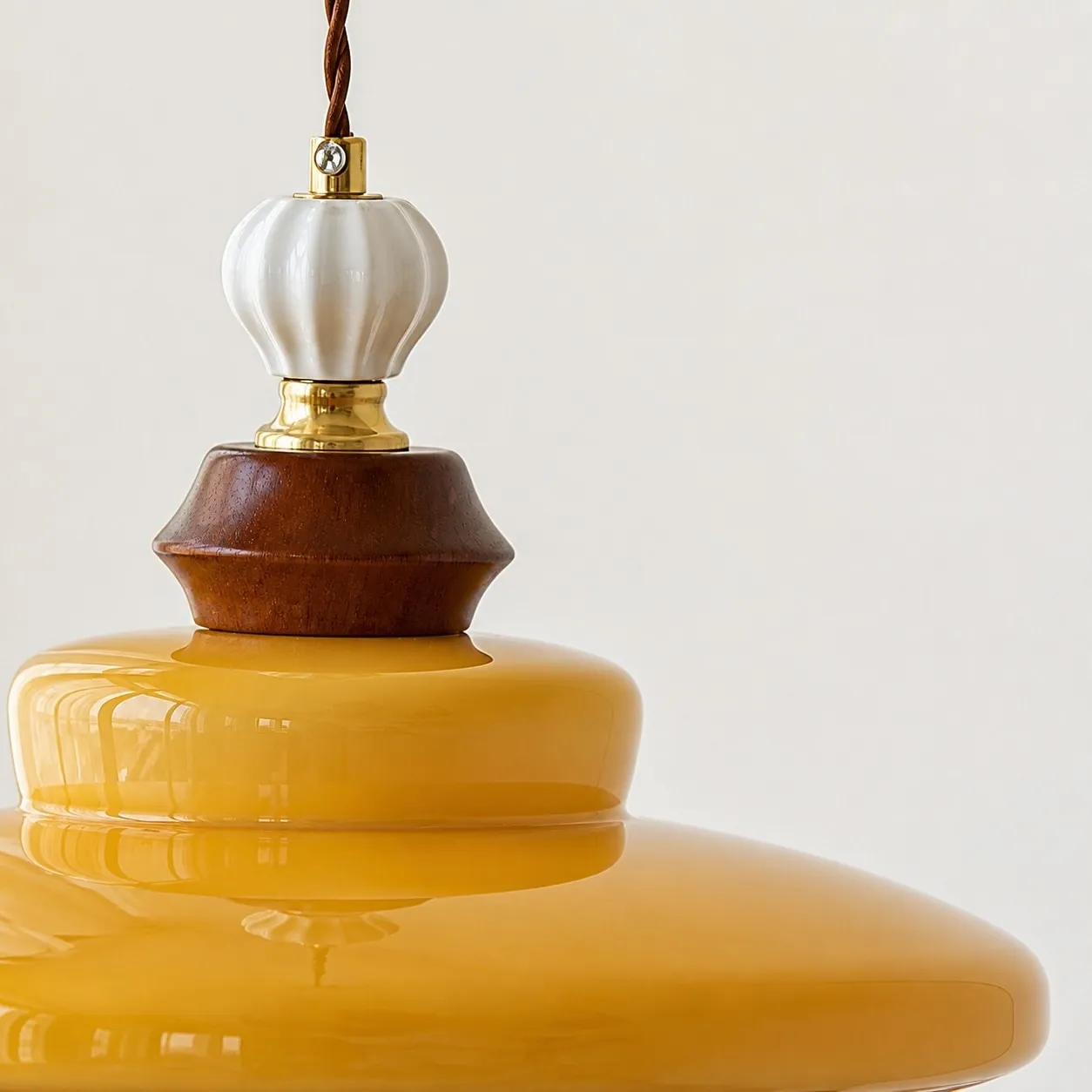 Pendant cord, wood accent, and caramel glass shade detail