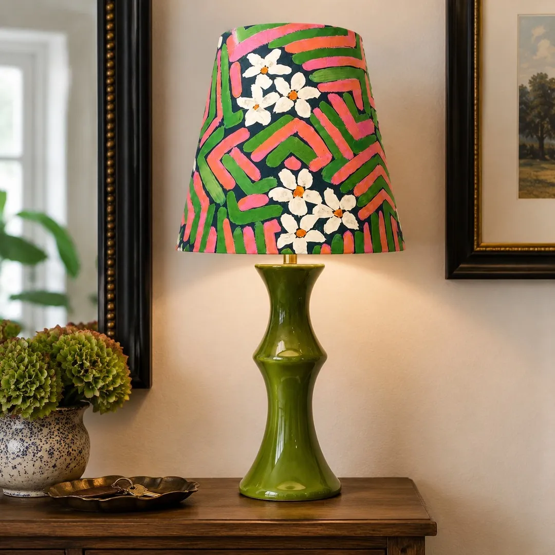 Pink and green table lamp on a wooden console
