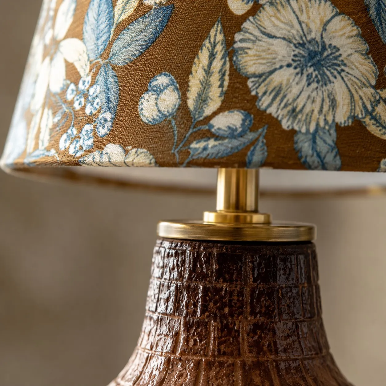 Close view of blue floral fabric lampshade and ceramic neck