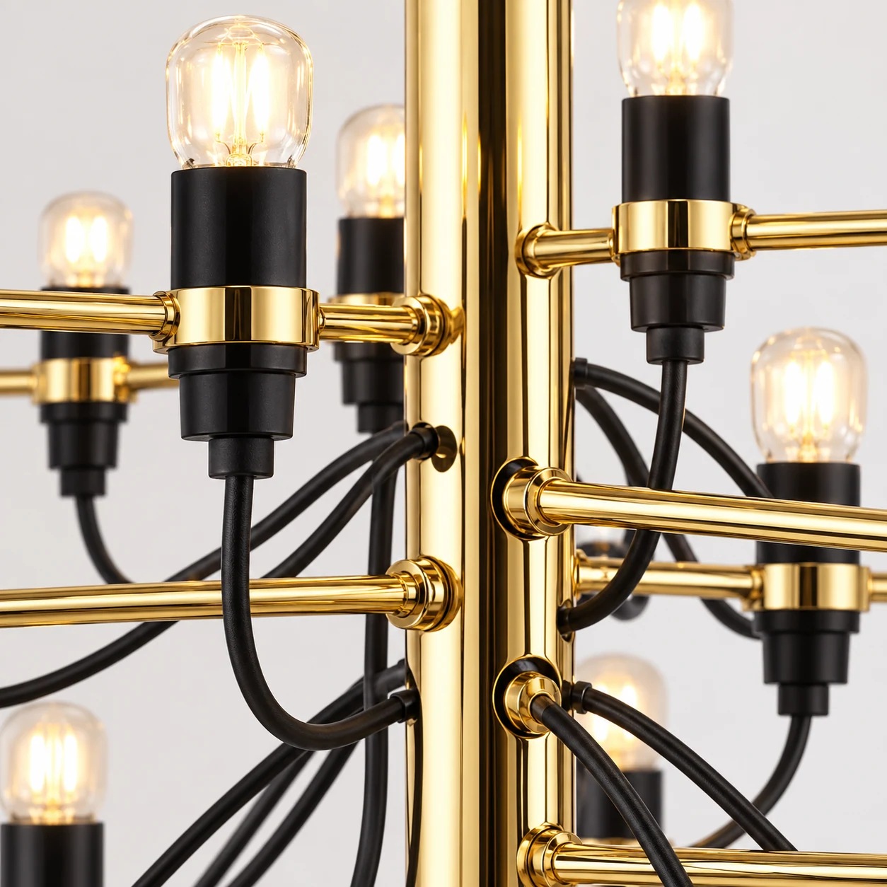 Close-up of the Tendrila chandelier's gold-toned metal arms, bulb holders and exposed wiring